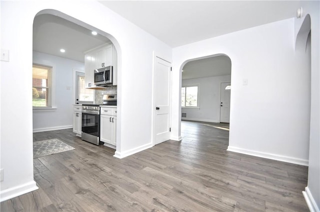 kitchen featuring white cabinets, appliances with stainless steel finishes, and dark wood-type flooring