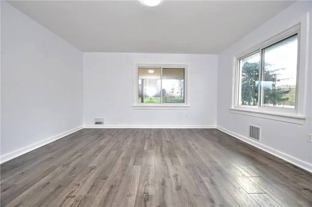 empty room with dark hardwood / wood-style flooring