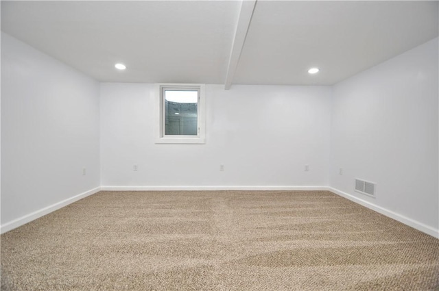 unfurnished room featuring beamed ceiling and carpet floors