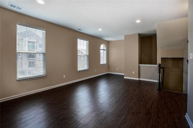 empty room featuring dark hardwood / wood-style flooring and plenty of natural light