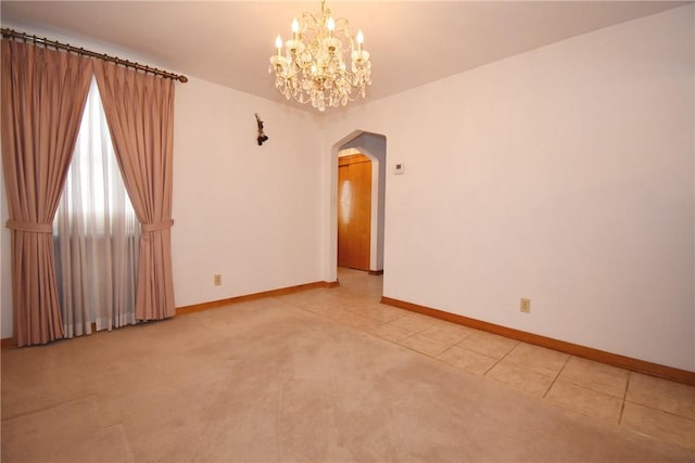 empty room with a chandelier and carpet