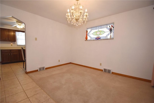 unfurnished dining area with ceiling fan with notable chandelier and light tile patterned floors