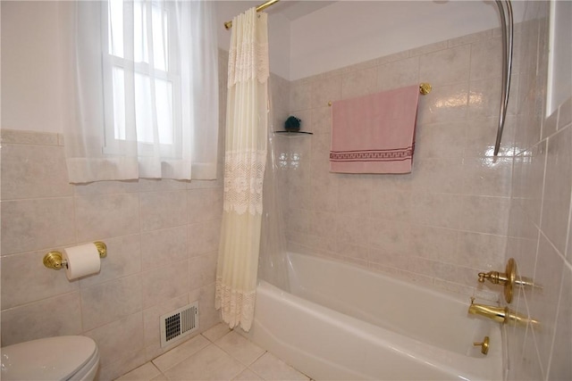 bathroom featuring tile patterned flooring, shower / bath combination with curtain, toilet, and tile walls