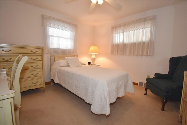 carpeted bedroom with ceiling fan and multiple windows