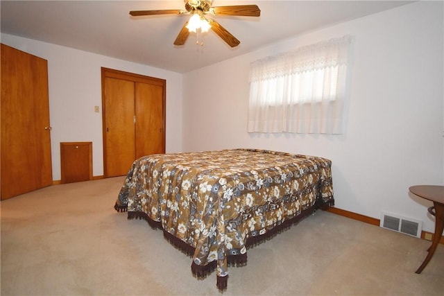 bedroom featuring ceiling fan, a closet, and light carpet