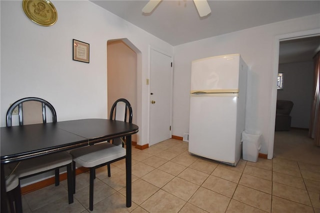 dining space featuring ceiling fan and light tile patterned floors