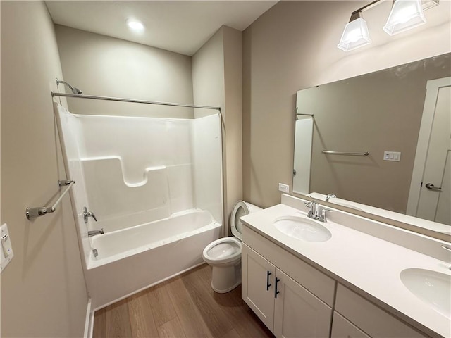 bathroom with shower / tub combination, a sink, toilet, and wood finished floors