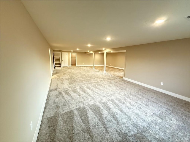 unfurnished living room with light carpet, visible vents, baseboards, and recessed lighting