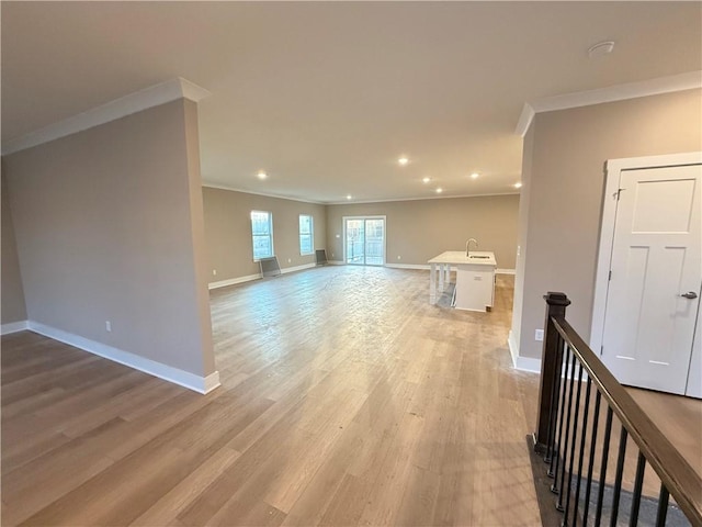 unfurnished living room featuring ornamental molding, recessed lighting, light wood-style flooring, and baseboards