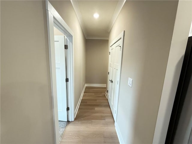 hall featuring ornamental molding, light wood-style flooring, and baseboards