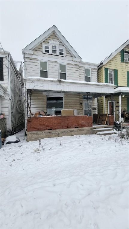 snow covered house with covered porch