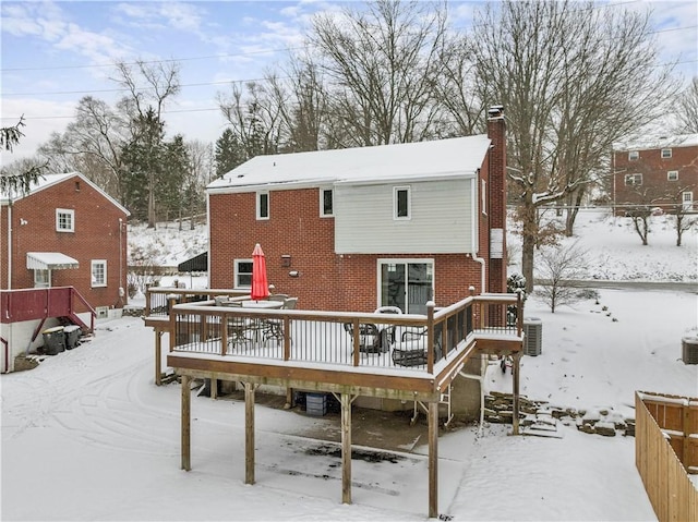 snow covered house featuring a wooden deck