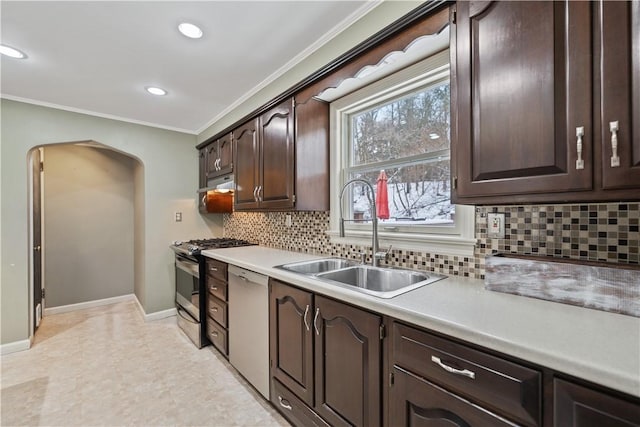 kitchen with dark brown cabinetry, sink, stainless steel gas range oven, backsplash, and white dishwasher