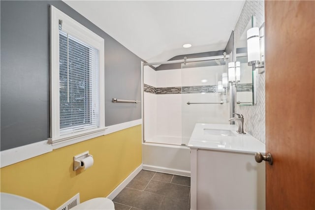 full bathroom featuring tile patterned floors, tiled shower / bath combo, toilet, and vanity