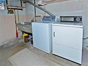 washroom with washer and dryer, laundry area, and a sink