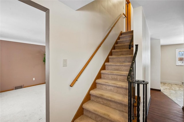 staircase with visible vents and baseboards