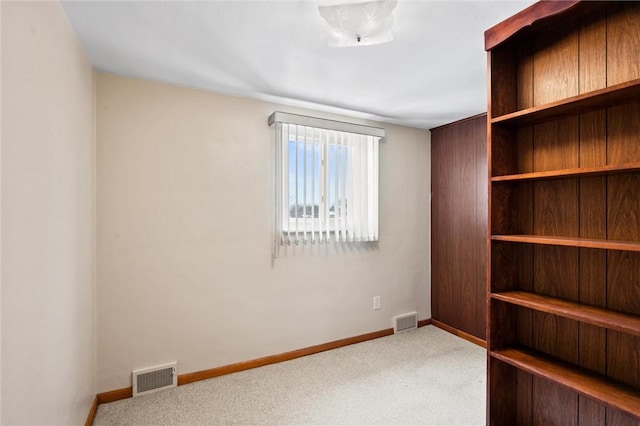 empty room featuring carpet, visible vents, and baseboards