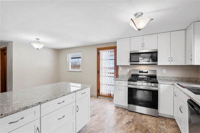 kitchen featuring stainless steel appliances, light stone countertops, and white cabinetry