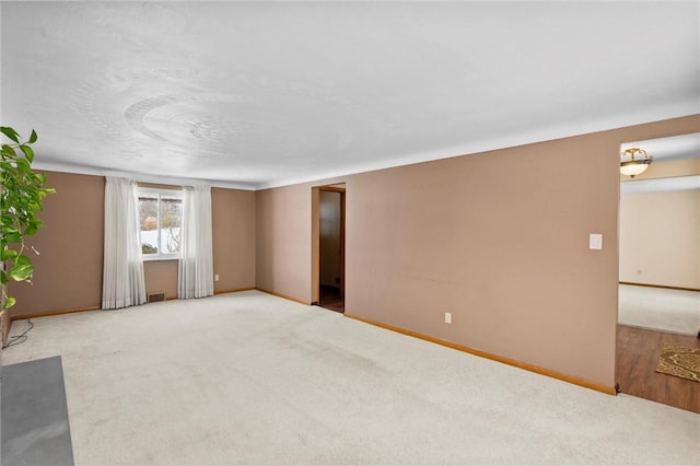 carpeted empty room with visible vents and baseboards