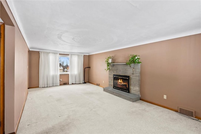 unfurnished living room with visible vents, carpet floors, baseboards, and a glass covered fireplace