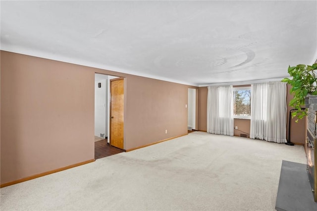 carpeted empty room with visible vents and baseboards