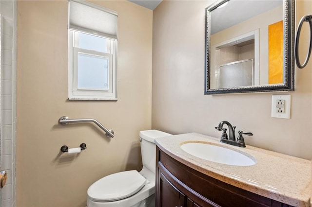 full bath featuring a shower with door, toilet, and vanity