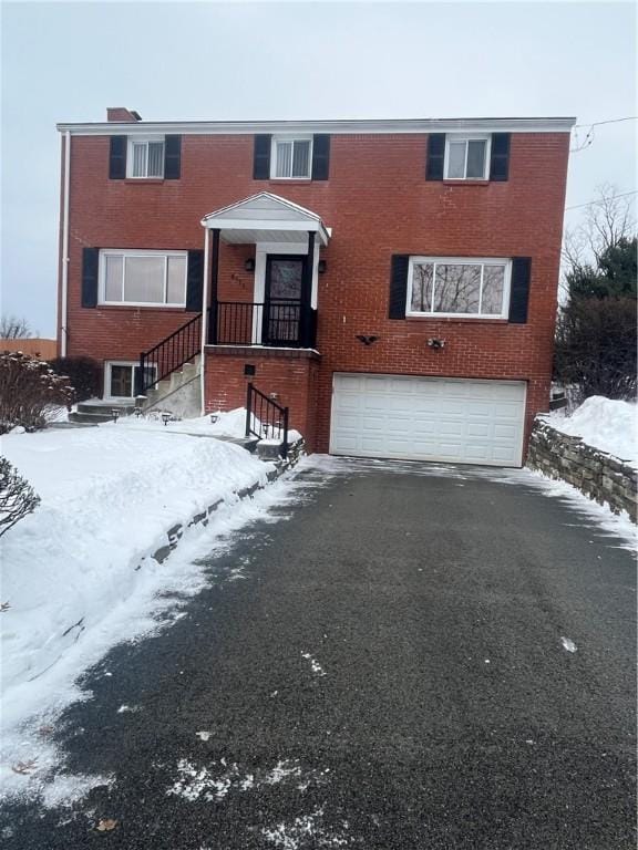 view of front facade featuring an attached garage, brick siding, and driveway