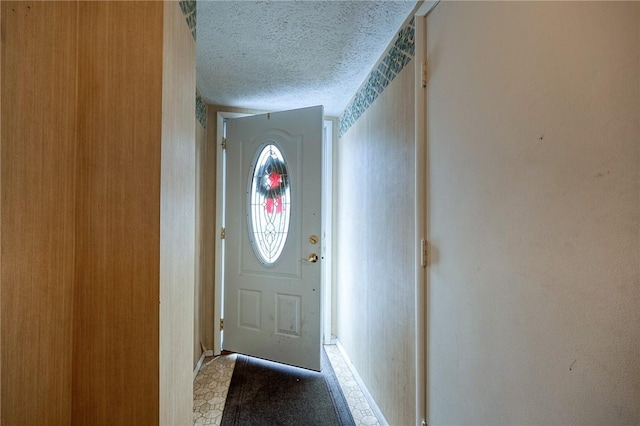 doorway to outside with a textured ceiling