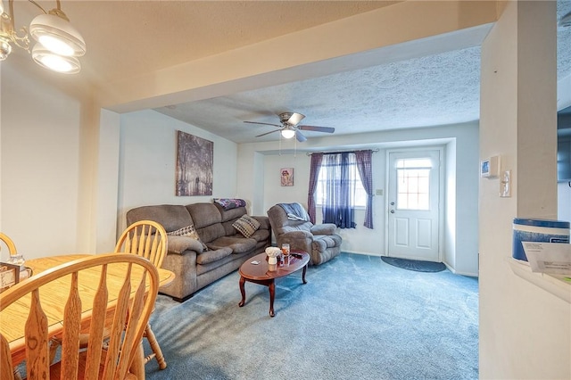 carpeted living room featuring a textured ceiling and ceiling fan