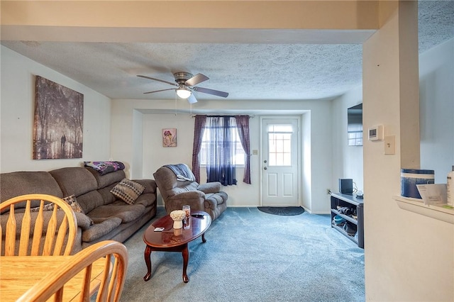 living room featuring carpet flooring, a textured ceiling, and ceiling fan