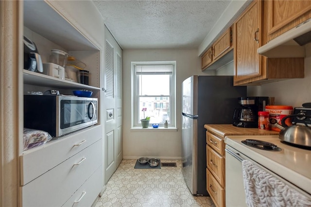 kitchen with a textured ceiling, stainless steel appliances, and extractor fan