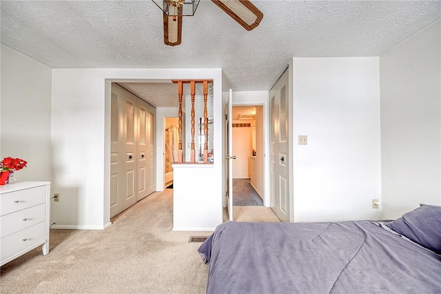 bedroom with light carpet, a textured ceiling, a closet, and ceiling fan