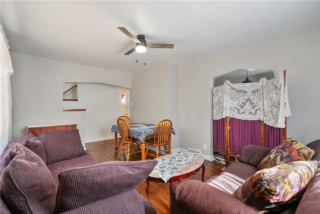 living room featuring ceiling fan and dark hardwood / wood-style floors