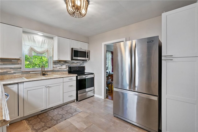 kitchen featuring decorative backsplash, white cabinetry, sink, and appliances with stainless steel finishes