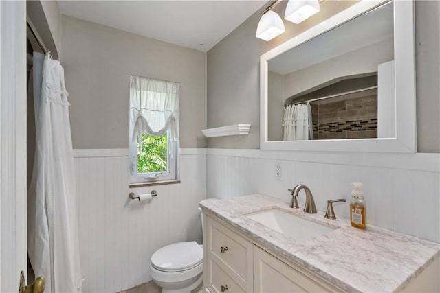 bathroom with a shower with shower curtain, vanity, and toilet