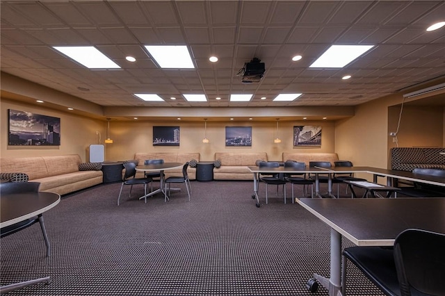 interior space featuring a paneled ceiling and dark carpet