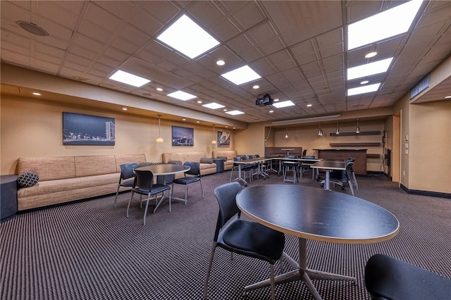 carpeted dining space featuring a drop ceiling