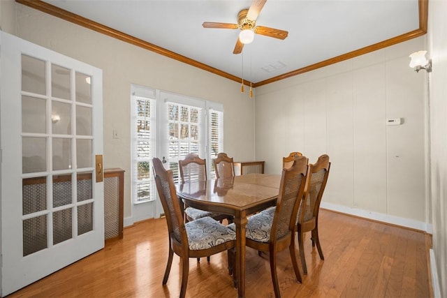 dining space with hardwood / wood-style flooring, ceiling fan, and ornamental molding