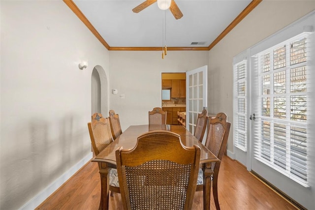 dining room featuring ceiling fan, crown molding, and light hardwood / wood-style flooring