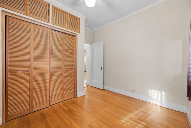 unfurnished bedroom with light wood-type flooring, a closet, crown molding, and ceiling fan