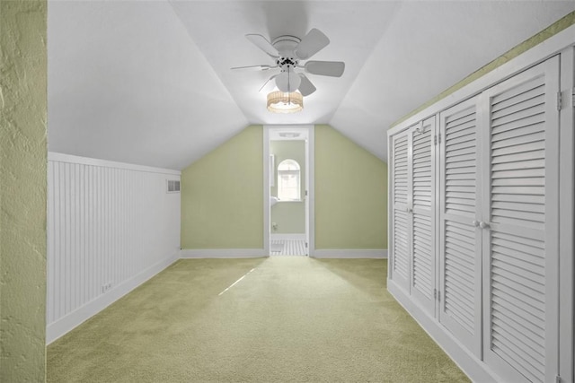 additional living space featuring light colored carpet, ceiling fan, and lofted ceiling