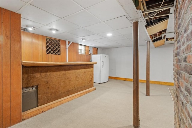 basement with bar, a paneled ceiling, carpet floors, and white refrigerator