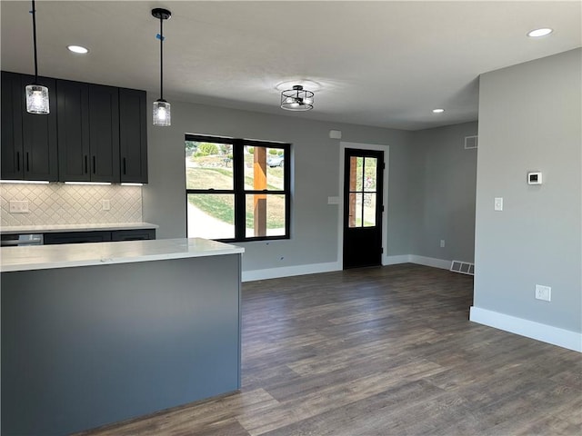 kitchen featuring backsplash, dark wood-type flooring, and pendant lighting