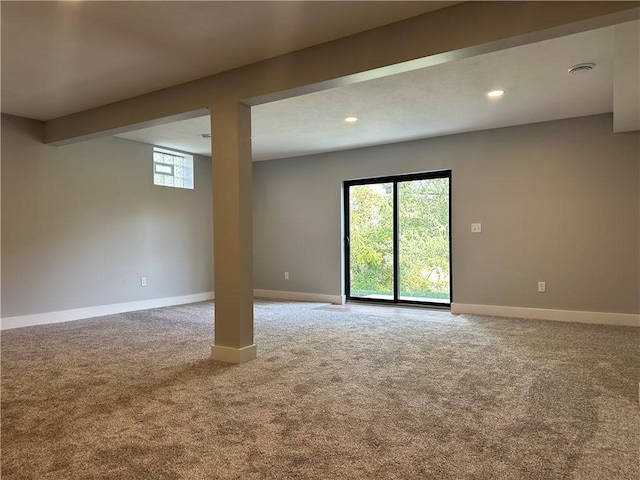 carpeted empty room featuring beamed ceiling