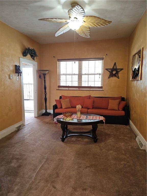 carpeted living room with ceiling fan