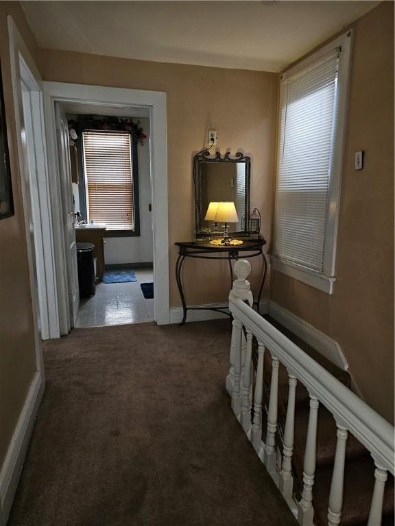 hall featuring dark colored carpet