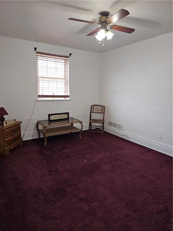 living area featuring dark carpet and ceiling fan