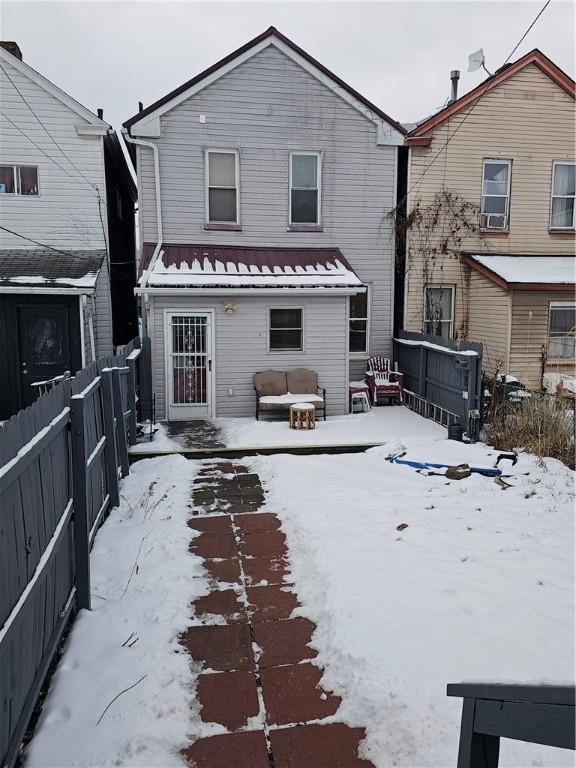 view of snow covered rear of property