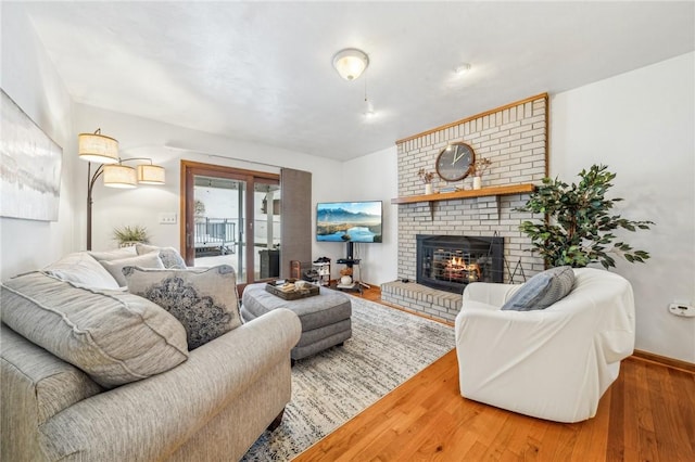 living room with a brick fireplace and wood-type flooring