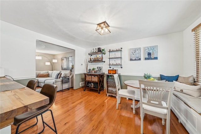 dining room featuring hardwood / wood-style floors and bar area